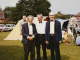Three band members in formal dress at an outdoor event